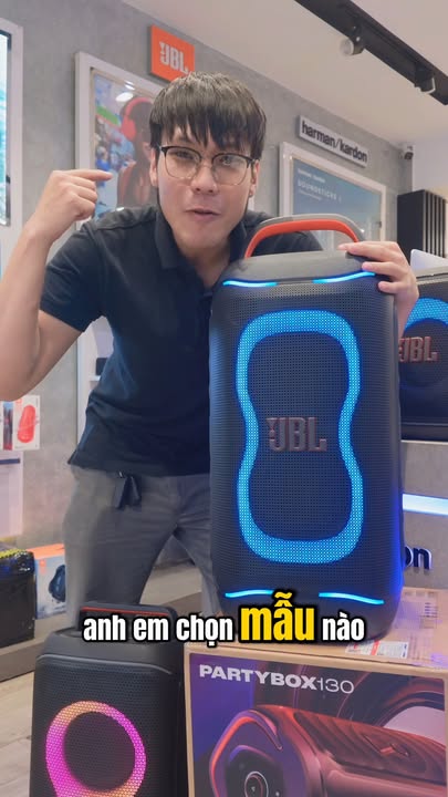 SO SÁNH NHANH JBL PARTYBOX 130 VS CLUB 120! ???????? JBL PartyBox Club 120 vốn đã là "ông hoàng tiệc tùng" phân khúc di động. Nhưng khi tân binh JBL PartyBox 130 chính thức chào sân với loạt nâng cấp mạnh tay, câu hỏi lớn nhất được anh em đặt ra: Có đáng để nâng cấp không? Trong clip hôm nay, hãy cùng soi từng chi tiết và nghe thử chất âm thực tế để xem 200W của PartyBox 130 có "thổi bay" người tiền nhiệm hay không nhé! Những điểm khác biệt "đáng đồng tiền bát gạo" trong clip: Công suất bứt phá (200W RMS vs 160W RMS): PartyBox 130 nâng mức công suất lên 200W. Khi đẩy volume lên trên 70% đến max 100%, dải bass vẫn đánh căng, chắc nịch và kiểm soát tốt, khắc phục hoàn toàn hiện tượng hụt lực. Thêm cổng Optical (Quang học) cực tiện: Điểm "ăn tiền" nhất cho gia đình! Cắm thẳng cáp quang từ Smart TV vào loa để hát karaoke hoặc xem phim mà không lo trễ tiếng (delay) như qua Bluetooth. Kết nối Bluetooth 6.0 & Smart EQ: Chuẩn kết nối mới giúp đường truyền siêu mượt, độ trễ cực thấp kết hợp chế độ Smart EQ tự cân chỉnh âm thanh thông minh theo từng thể loại. Pin trâu hơn (15 giờ vs 12 giờ): Thời lượng chơi nhạc tăng lên 15 tiếng, vẫn giữ thiết kế pin rời linh hoạt và hỗ trợ sạc nhanh – quẩy xuyên đêm không lo đứt đoạn. Lightshow & Giao diện mới: Dải đèn LED mặt trước được tinh chỉnh bắt mắt hơn, bổ sung nút cảm ứng trên bảng điều khiển giúp thao tác mượt mà. Vậy ta nên chọn mẫu nào: Club 120: Vẫn là chiếc loa cực kỳ đáng mua trong tầm giá, cân tốt các không gian phòng khách nhỏ và tiệc ngoài trời nhẹ nhàng. PartyBox 130: Dành cho những ai muốn lực bass dày hơn, âm lượng lớn hơn, đặc biệt là cần một thiết bị "all-in-one" vừa đi du lịch vừa làm dàn karaoke phòng khách kết nối TV không độ trễ.